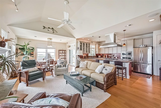 living room with ceiling fan, recessed lighting, visible vents, vaulted ceiling, and light wood-type flooring