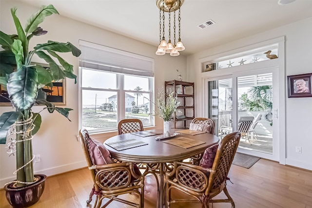 dining room with visible vents, baseboards, and wood finished floors