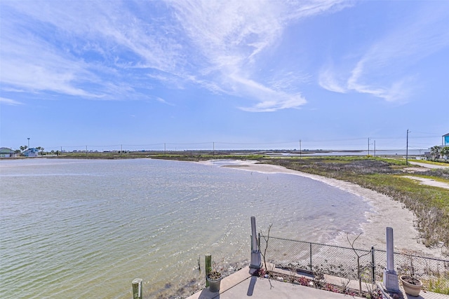 view of water feature featuring fence and a beach view