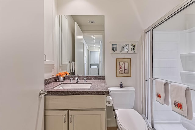 bathroom with toilet, a shower stall, visible vents, and vanity