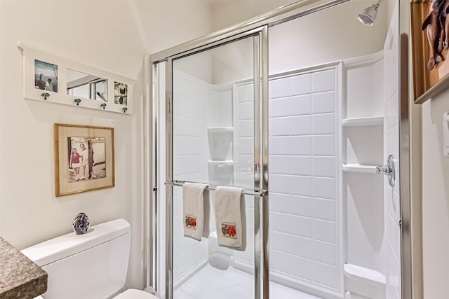 full bathroom featuring a stall shower and toilet