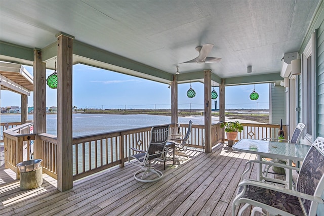 deck with a water view and ceiling fan