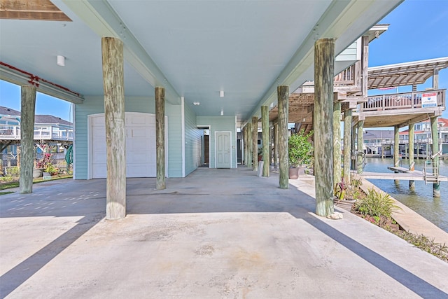 view of patio featuring a water view and a garage