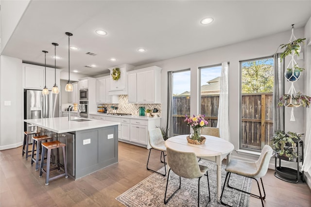 kitchen with tasteful backsplash, visible vents, appliances with stainless steel finishes, light countertops, and a sink