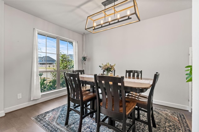 dining area with a notable chandelier, plenty of natural light, wood finished floors, and baseboards