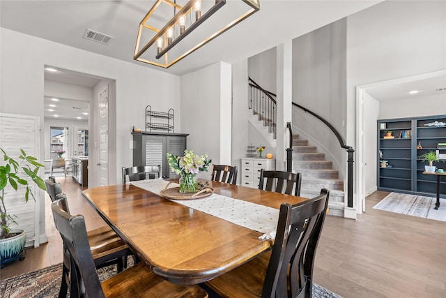 dining area featuring stairs, wood finished floors, and visible vents