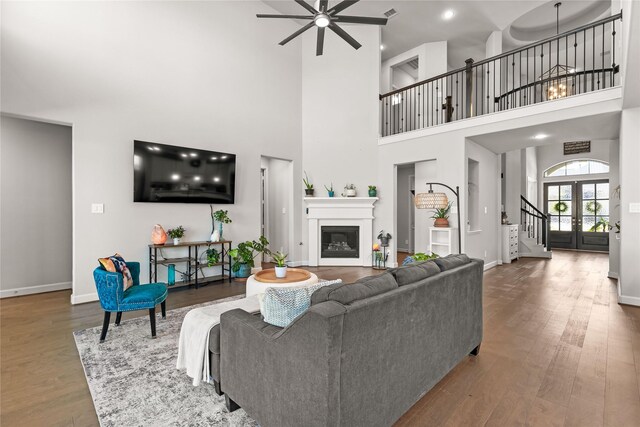 living room with baseboards, french doors, wood finished floors, and a glass covered fireplace