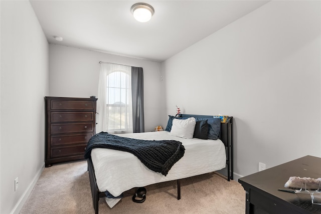 bedroom featuring light carpet and baseboards