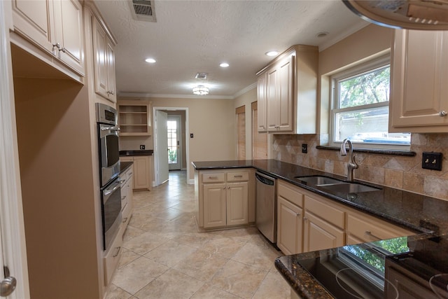 kitchen with a peninsula, a sink, visible vents, ornamental molding, and stainless steel dishwasher