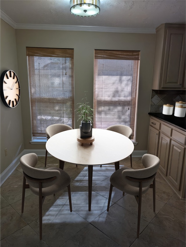 dining area with crown molding, baseboards, and a healthy amount of sunlight