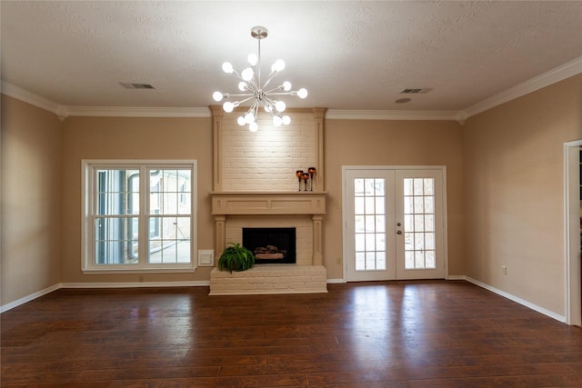 unfurnished living room with visible vents, french doors, a brick fireplace, dark wood finished floors, and crown molding