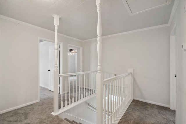 corridor featuring carpet floors, baseboards, crown molding, and an upstairs landing