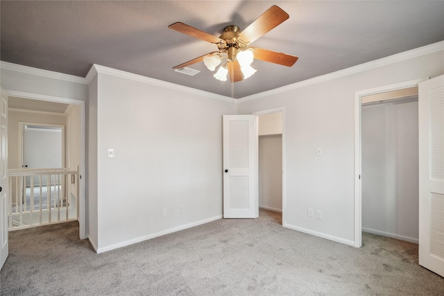 unfurnished bedroom with ceiling fan, ornamental molding, carpet flooring, and baseboards