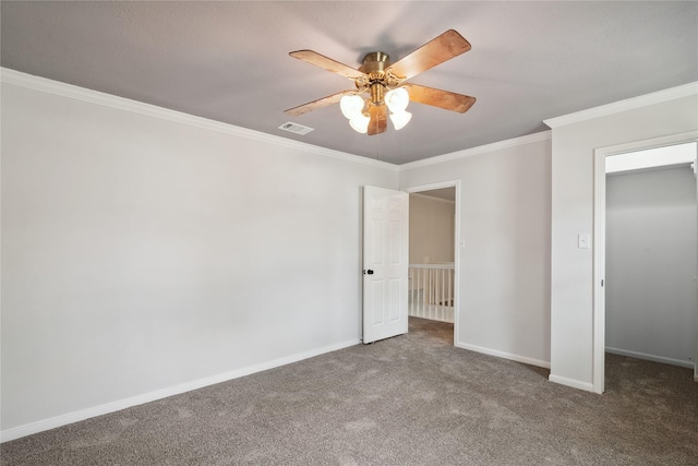 unfurnished bedroom featuring carpet, visible vents, crown molding, and baseboards