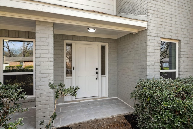 view of exterior entry featuring brick siding