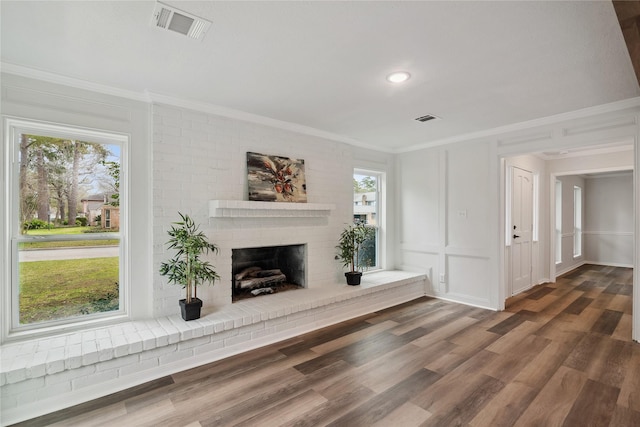 unfurnished living room with a decorative wall, visible vents, and crown molding