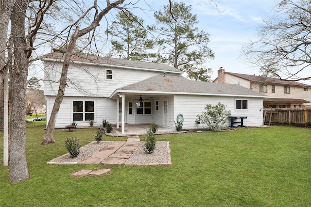 back of house featuring fence, a ceiling fan, a lawn, a chimney, and a patio area