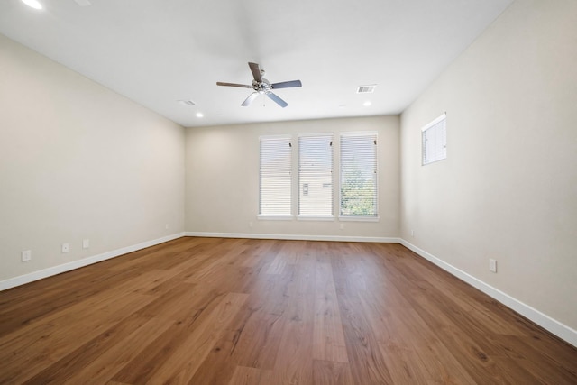 empty room featuring recessed lighting, visible vents, ceiling fan, wood finished floors, and baseboards