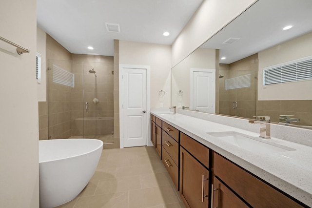 full bath featuring a sink, a shower stall, a freestanding bath, and double vanity