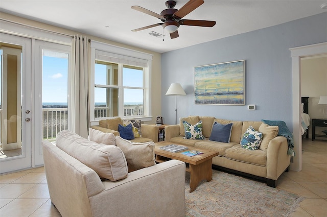 living area with light tile patterned flooring, visible vents, and ceiling fan