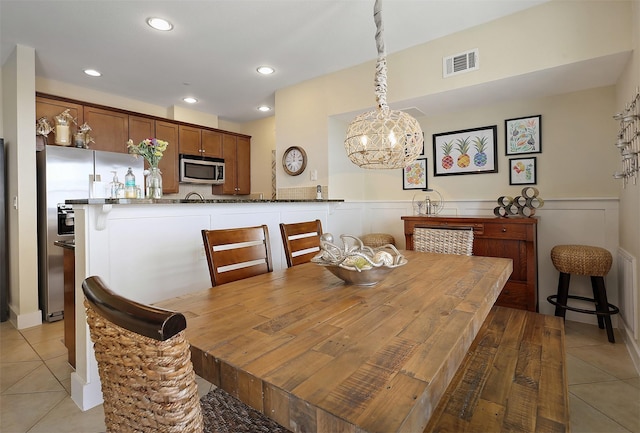 dining room with a wainscoted wall, light tile patterned floors, recessed lighting, and visible vents