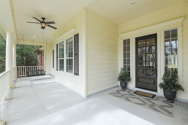 view of exterior entry with a porch and ceiling fan