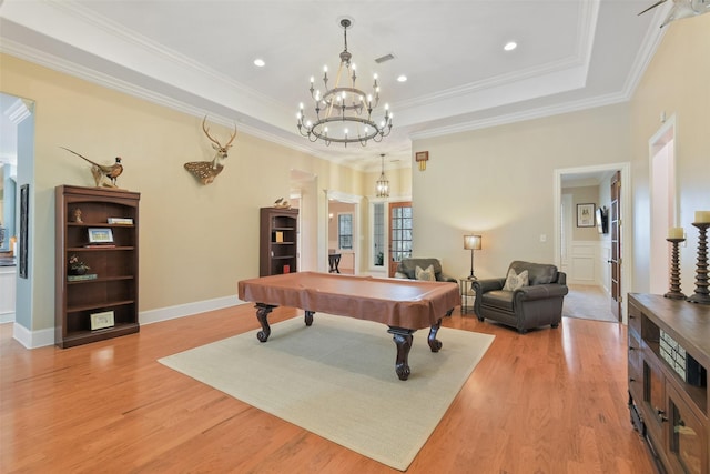 recreation room with pool table, a tray ceiling, light wood finished floors, and ornamental molding