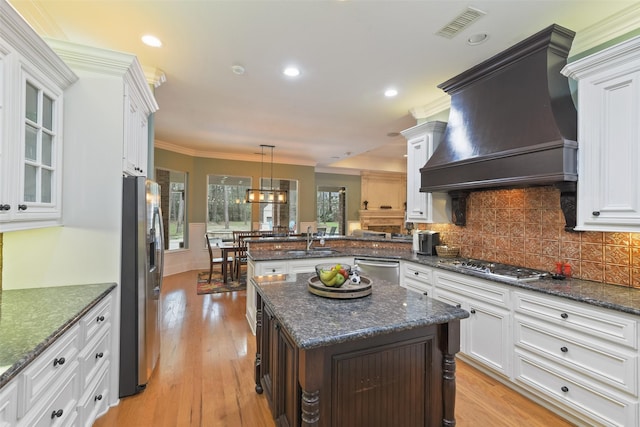 kitchen featuring visible vents, custom range hood, a sink, appliances with stainless steel finishes, and white cabinets