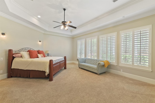 bedroom with a tray ceiling, multiple windows, baseboards, and ornamental molding