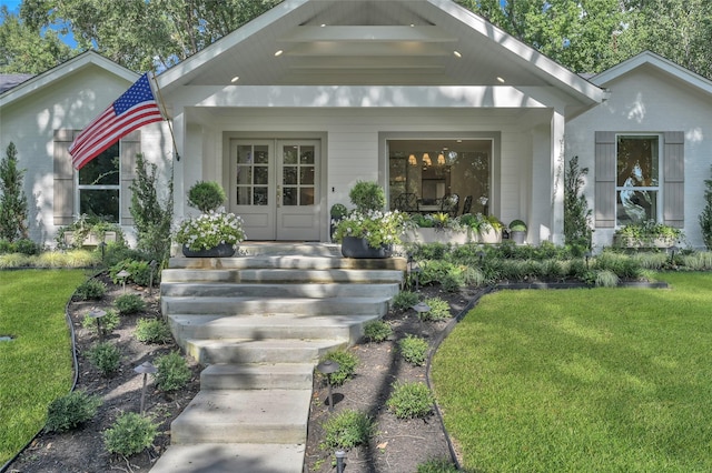 view of front of property with french doors, covered porch, and a front lawn