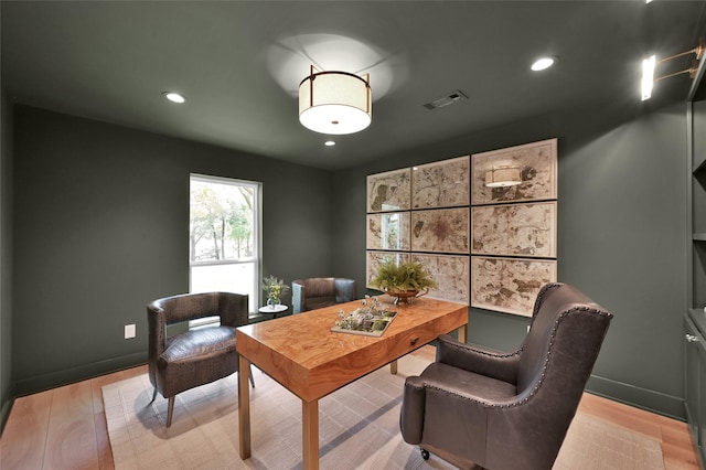 office with light wood-type flooring, baseboards, and visible vents