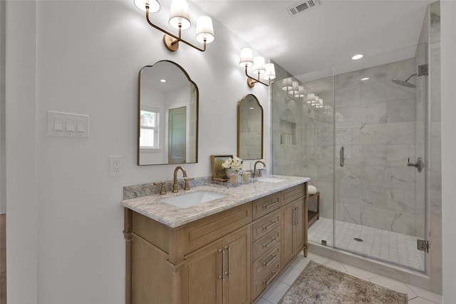 bathroom featuring a stall shower, visible vents, a sink, and tile patterned floors