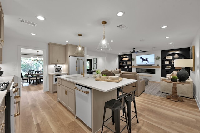 kitchen featuring dishwasher, gas range, light wood-type flooring, and visible vents