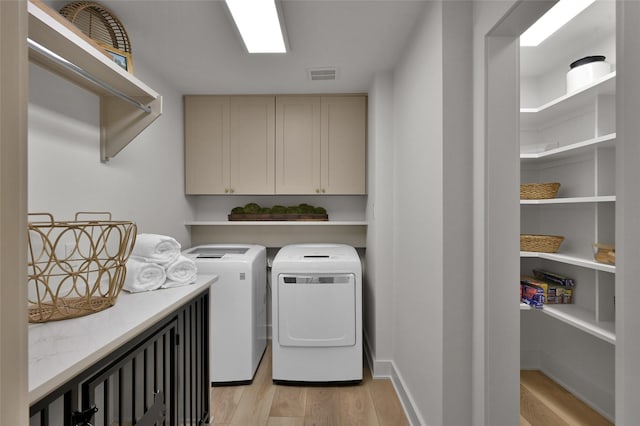 laundry area with independent washer and dryer, cabinet space, visible vents, and light wood-style floors