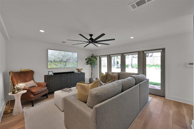 living area featuring baseboards, light wood-style flooring, visible vents, and recessed lighting