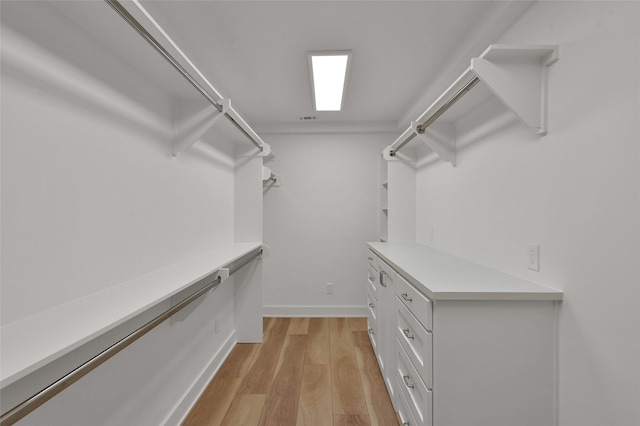 walk in closet with light wood-type flooring and visible vents