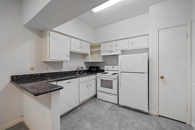 kitchen featuring under cabinet range hood, a peninsula, white appliances, white cabinets, and dark stone countertops