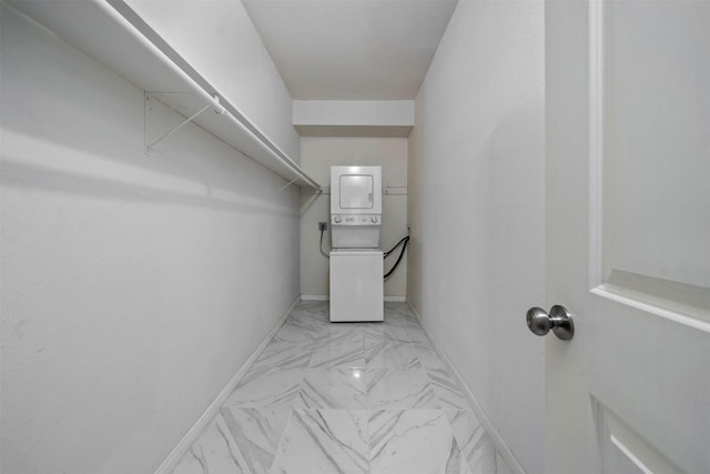 walk in closet with stacked washer / drying machine and marble finish floor