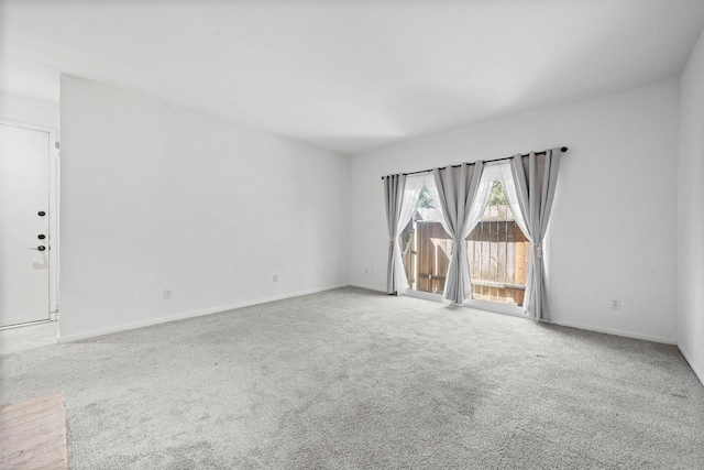 spare room with carpet and baseboards