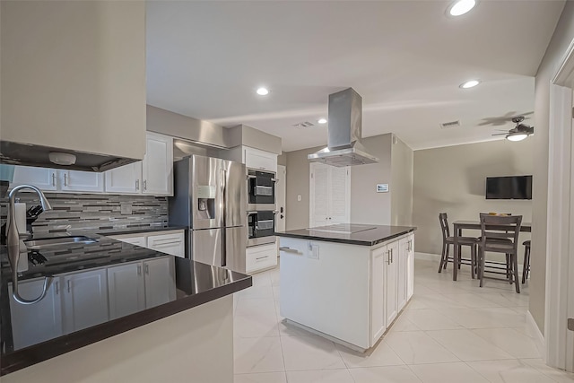 kitchen featuring visible vents, white cabinets, appliances with stainless steel finishes, dark countertops, and island exhaust hood