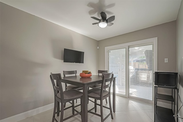 dining room featuring ceiling fan, baseboards, and light tile patterned flooring