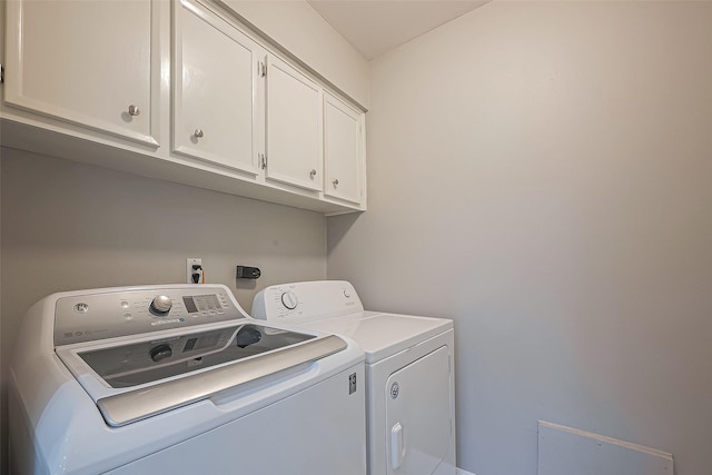 washroom featuring cabinet space and independent washer and dryer