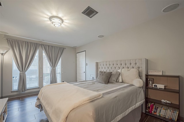 bedroom with access to outside, visible vents, and wood finished floors