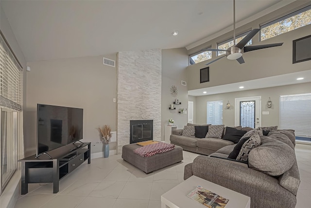 living area with high vaulted ceiling, a stone fireplace, recessed lighting, visible vents, and a ceiling fan