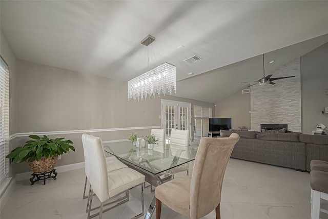 dining space with baseboards, visible vents, vaulted ceiling, french doors, and a fireplace