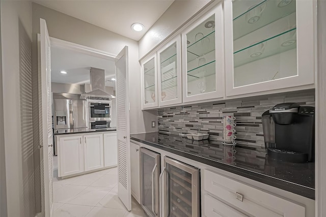 bar featuring wine cooler, appliances with stainless steel finishes, island exhaust hood, backsplash, and light tile patterned flooring