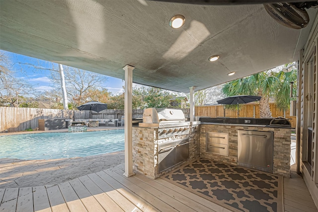 wooden deck featuring a fenced backyard, visible vents, and an outdoor kitchen