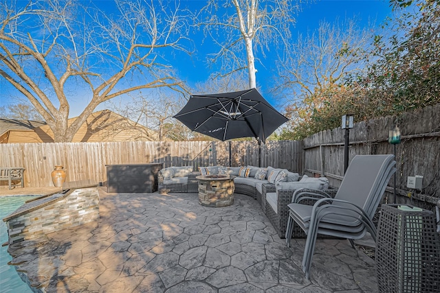 view of patio / terrace with a fenced backyard and an outdoor living space with a fire pit