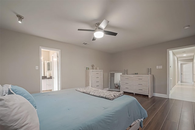 bedroom featuring visible vents, baseboards, a ceiling fan, dark wood-style floors, and ensuite bath