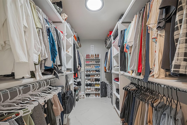 walk in closet featuring marble finish floor